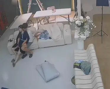 Hackers crack the webcam to monitor and secretly photograph the studio. When there is no one else in the studio, the photographer's obscene wife of shop-owner makes out with her.